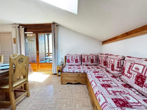 une chambre avec quatre lits avec des oreillers rouges et blancs dans l'établissement Appartement pour 6 pers. avec piscine et parking privatif - FR-1-505-109, à Flumet