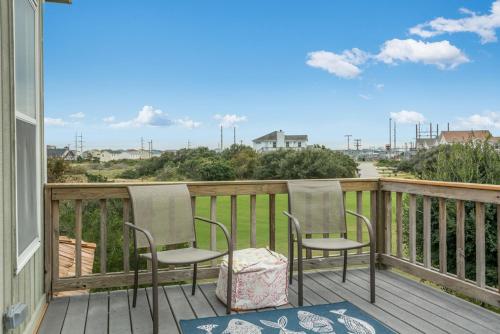 two chairs on a porch with a view of the ocean at Baymeadow 10 in Nags Head