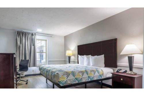 a hotel room with a bed and a desk at Motel 6 Dallas TX Downtown in Dallas