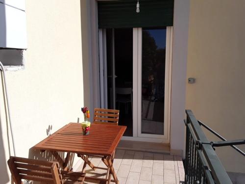 a wooden table and chairs on a balcony with a window at Il Tuffatore in Capaccio-Paestum
