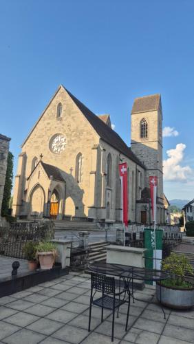 a church with a bench in front of it at Cruise durch das Herz der Altstadt in Rapperswil-Jona