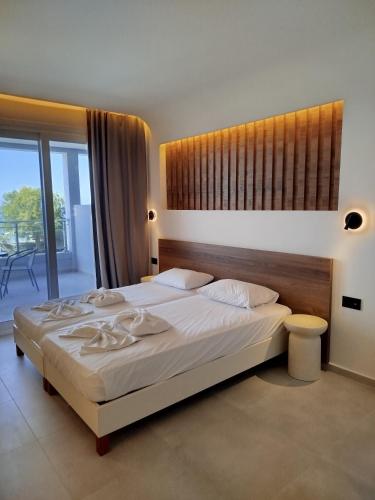 una habitación con una cama grande y un balcón en Neon Hotel, en Stalida
