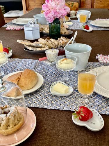 - une longue table avec des assiettes de nourriture et de boissons dans l'établissement Chambre Forêt, à Thannenkirch