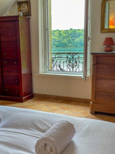 a bedroom with a bed with a window and a dresser at Rivage secret in Lézardrieux