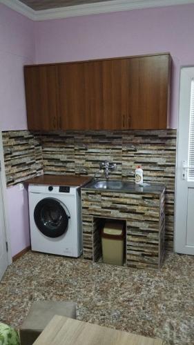 a kitchen with a washing machine and a sink at Barateli in Kutaisi