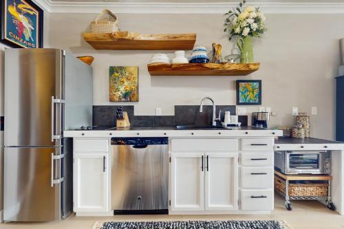 a kitchen with white cabinets and a stainless steel refrigerator at The Beach Suite in Langley