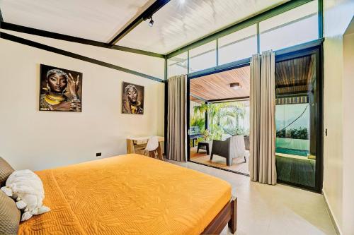 Un dormitorio con una cama y una ventana grande. en Casa Gaviota 1 - Pool, comfort & great location, en Puerto Viejo