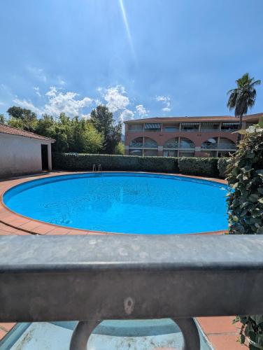 une grande piscine bleue devant un immeuble dans l'établissement Cala Di sognu Moriani plage face à la mer, à San-Nicolao