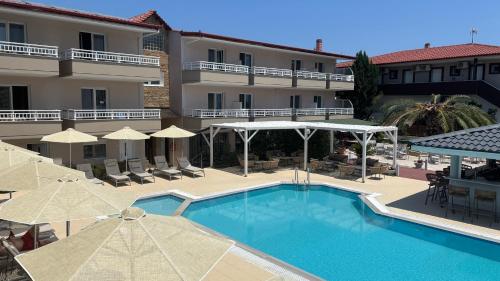 a swimming pool with umbrellas and a hotel at Sarti Plaza in Sarti