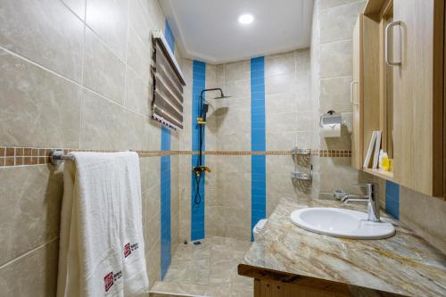 a bathroom with a sink and a shower at Bays Lodge, Accra in Accra