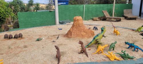 a group of toy dinosaurs on the sand at Pousada Itatiba Holliday in Itatiba