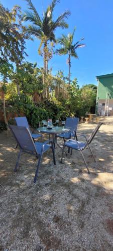a picnic table and two chairs and palm trees at Pousada Itatiba Holliday in Itatiba