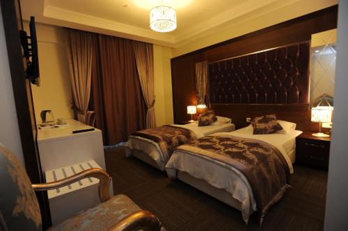 a hotel room with two beds and a large headboard at Vurna Butik Hotel in Trabzon