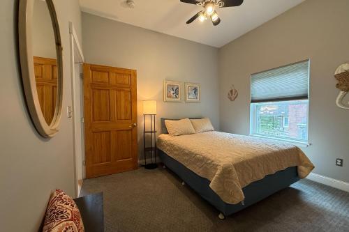 a bedroom with a bed and a window and a mirror at Sunshine Serenity in Wells