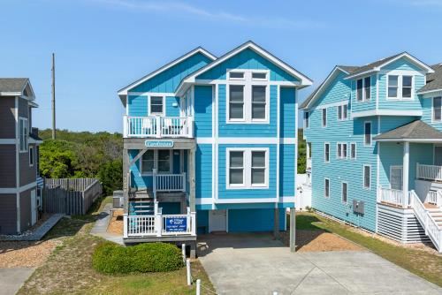 a blue house with a staircase in front of it at Carolinian in Nags Head
