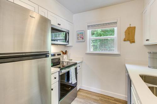 a kitchen with white cabinets and a stainless steel refrigerator at Walk to Ocean Springs Beach Condo with Pool! in Ocean Springs