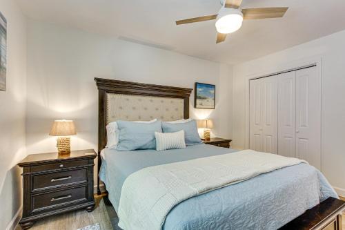 a bedroom with a blue bed and a night stand with a lamp at Walk to Ocean Springs Beach Condo with Pool! in Ocean Springs