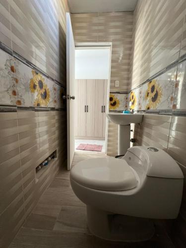 a bathroom with a toilet and a sink and a mirror at Bungalows Pascana 58 in Canoas de Punta Sal