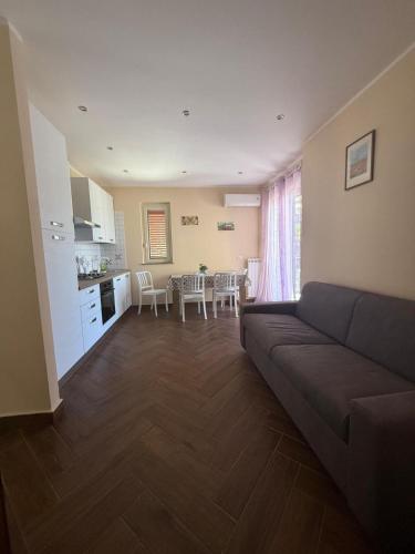 a living room with a couch and a kitchen and a table at Vista sullo Stretto in Messina