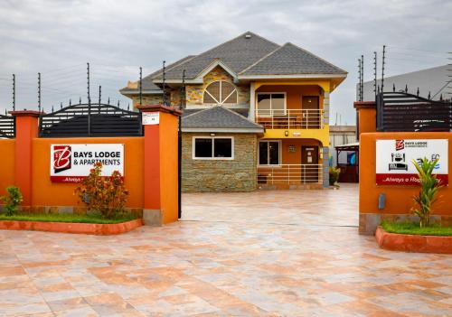 a house with orange walls and a parking lot at Bays Lodge, Accra in Accra
