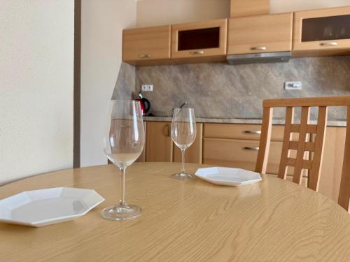 two wine glasses sitting on top of a wooden table at Penzion Apartmány Adamčík in Huštěnovice