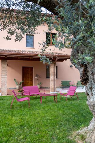 a group of pink chairs and tables in a yard at Tenuta Tortorella Agriturismo in Altavilla Silentina