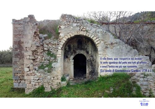 an old stone building with an arch in a field at B&B Corte degli Ulivi in Mattinata
