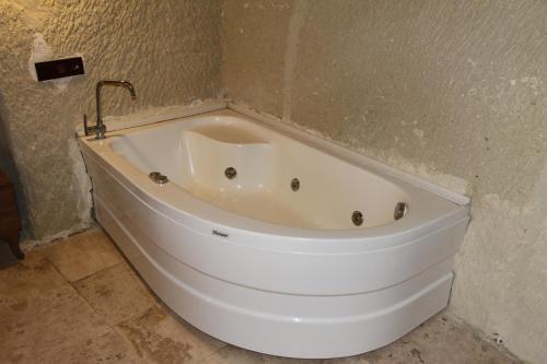 a white bath tub in a corner of a bathroom at Zen Cappadocia House in Goreme