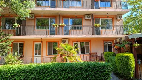 an orange building with plants in front of it at Вила Фернандес in Chernomorets