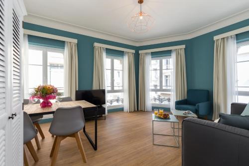 een woonkamer met blauwe muren en een tafel en stoelen bij Florella Antibes Apartment in Cannes