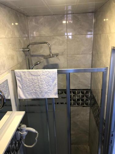a bathroom with a shower with a towel at GOLD SARAY PANSİYOn in Saray