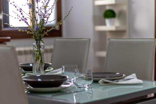a table with plates and a vase with flowers on it at Casa Mìmì in Rieti