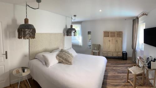 a bedroom with a white bed with two pillows at Hotel Restaurant O'Banel in Gallargues-Le-Montueux