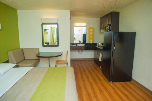 a room with a bed and a kitchen with a refrigerator at Motel 6-Palestine, TX in Palestine