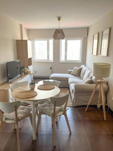 a living room with a couch and a table and chairs at Apartamento Son do Mar in Porto do Son