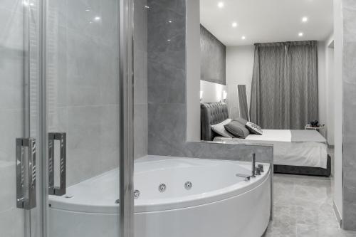 a bathroom with a tub and a bedroom with a bed at La Casa di Peppolo in Randazzo
