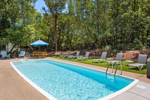 a pool with chairs and a table and an umbrella at Chillax in Duck