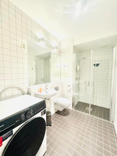 a white bathroom with a sink and a toilet at Tjuvholmen apartment 2BR in Oslo