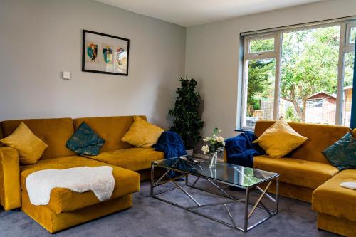 a living room with two couches and a glass table at Games Room free Parking House in Bristol