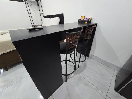 アパレシダ・デ・ゴイアニアにあるFlat completo a 24 minutos do Flamboyant Shoppingの黒いカウンター(1室につきバースツール2脚付)
