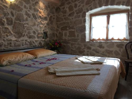 1 dormitorio con 1 cama en una habitación con ventana en Holiday Home Rasopas, en Malinska