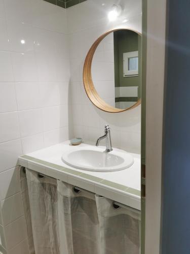 une salle de bain avec un lavabo et un miroir dans l'établissement Maison Romana, à Riez