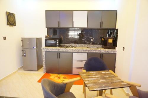 a kitchen with a table and two chairs and a counter at 2 Voies Résidence in Dakhla