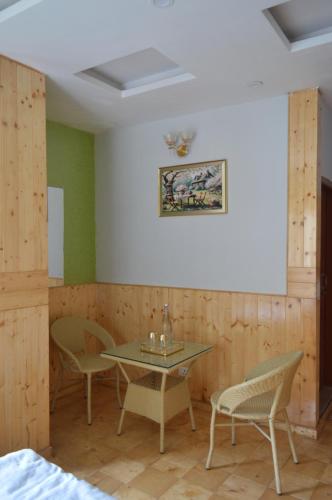 a table and chairs in a room with green walls at Nature Heaven Homestay in Mashobra