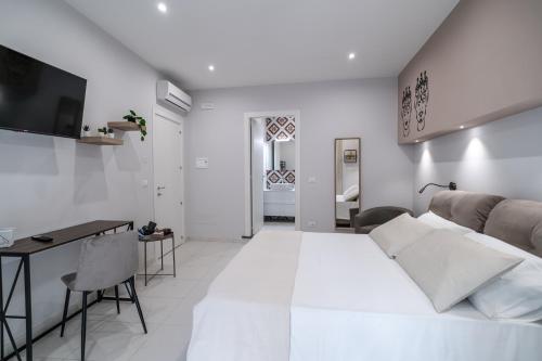 a white living room with a bed and a desk at La Casa di Peppolo in Randazzo