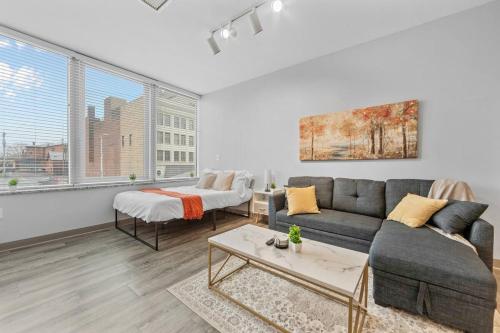 a living room with a couch and a table at MDRN Escape with Natural Light Wi-Fi Gym Parking in Cleveland