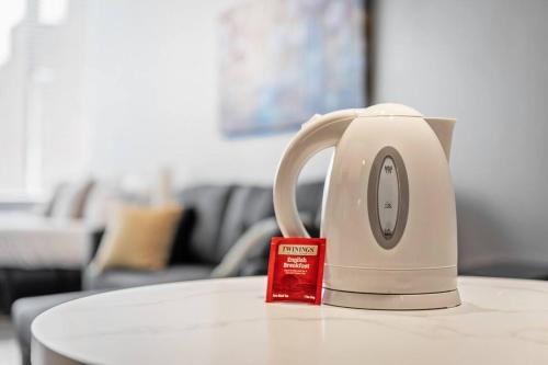 a tea kettle sitting on top of a table at MDRN Escape with Natural Light Wi-Fi Gym Parking in Cleveland