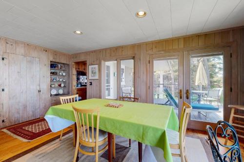 a dining room with a green table and chairs at Maddock Cove Cabin in Southport