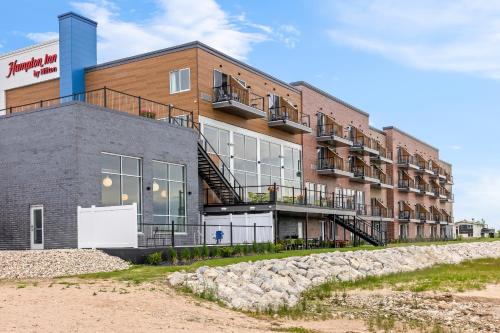 an apartment building with a staircase in front of it at Hampton Inn St Ignace Lakefront Mackinac in Evergreen Shores