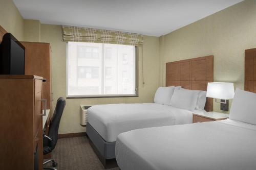 a hotel room with two beds and a window at Holiday Inn Express Manhattan Midtown West by IHG in New York